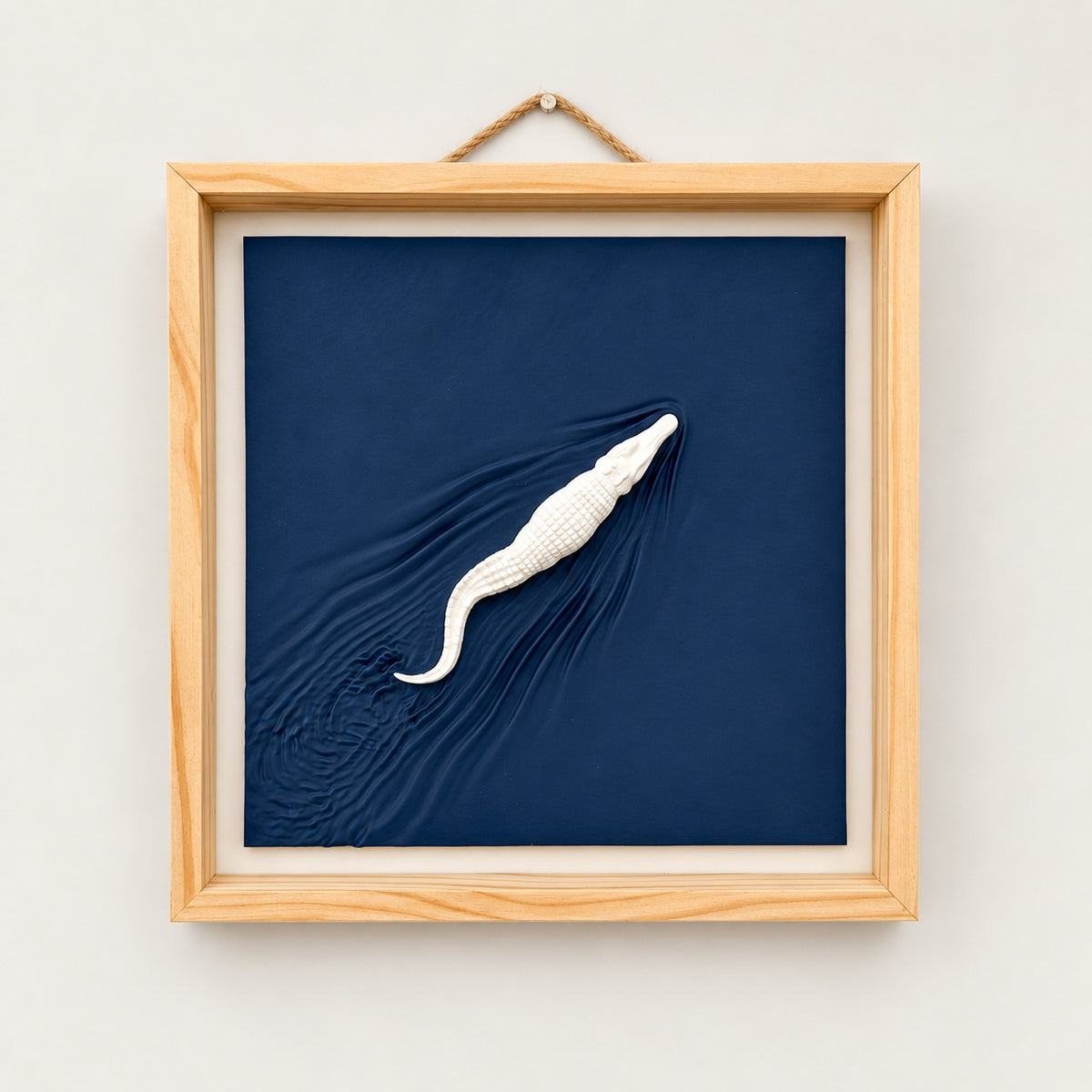 Alligator wall art with navy sculpted wake, natural wood frame and rope hanger, front view