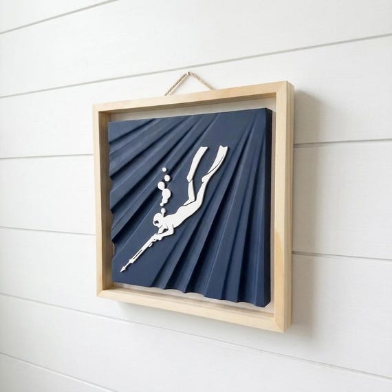 Spearfisher relief wall art with a navy sunray panel and natural wood frame, image 1.