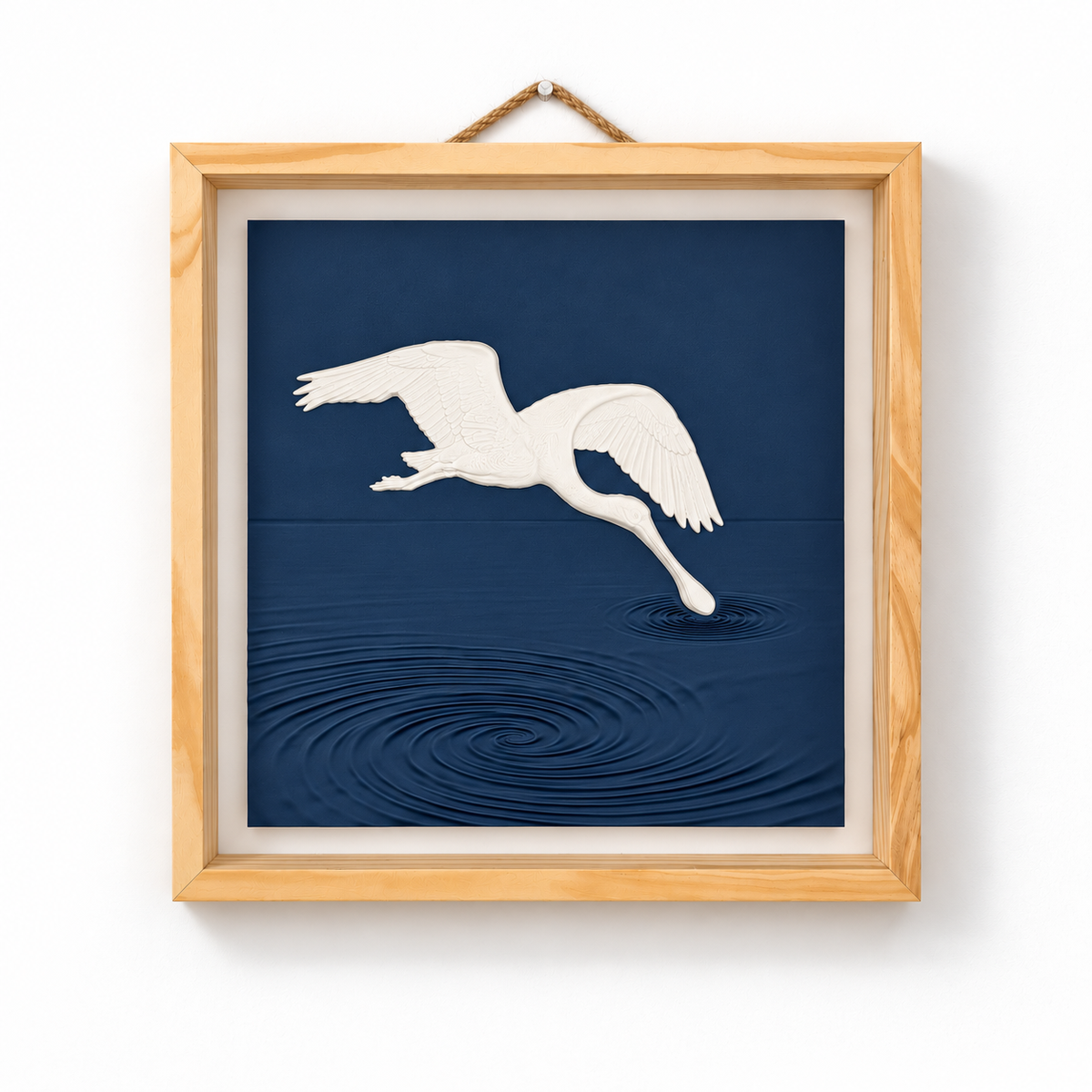 Front view of white spoonbill wall art above sculpted navy water ripples in a natural wood frame